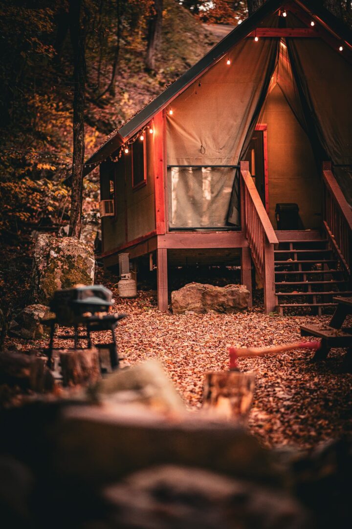 A cabin with a fire pit and stairs leading to the porch.