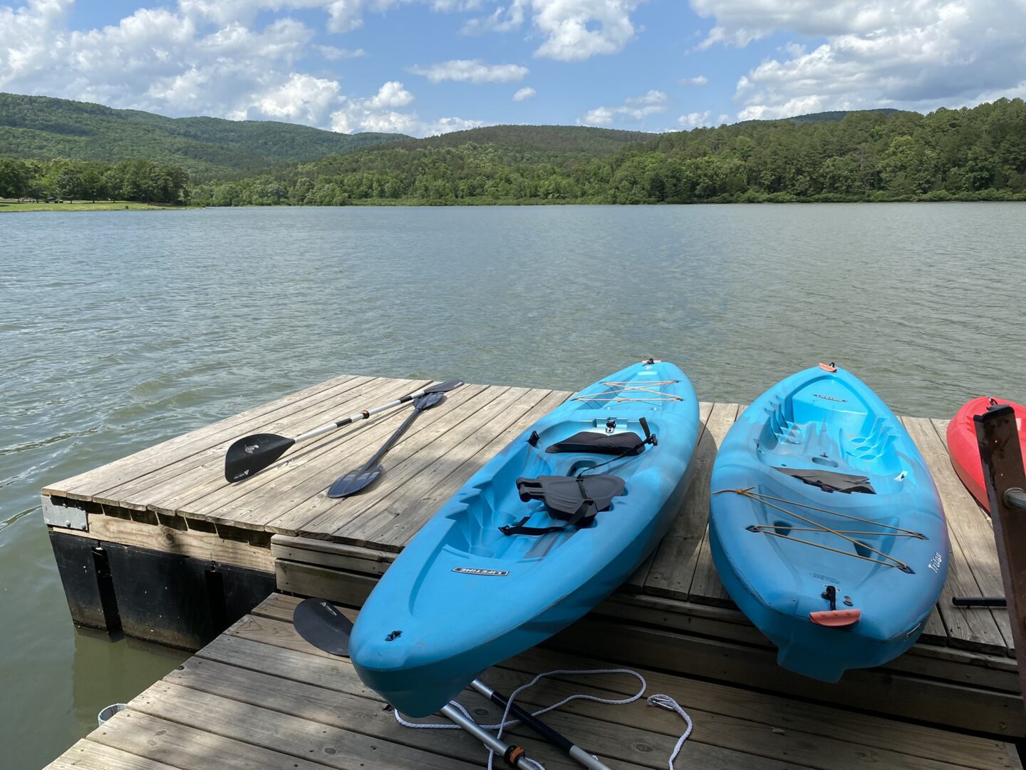Two blue kayaks are docked on a dock.