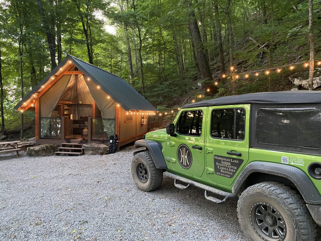 A jeep parked in front of a tent.