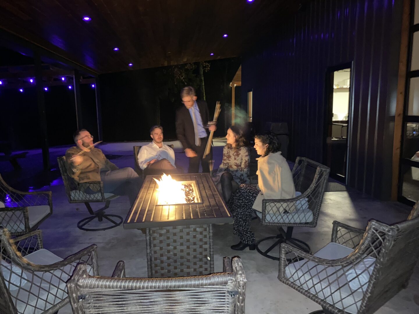 A group of people sitting around an outdoor fire pit.