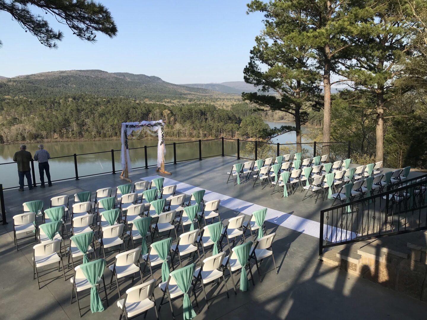 A wedding ceremony with chairs and a lake in the background.
