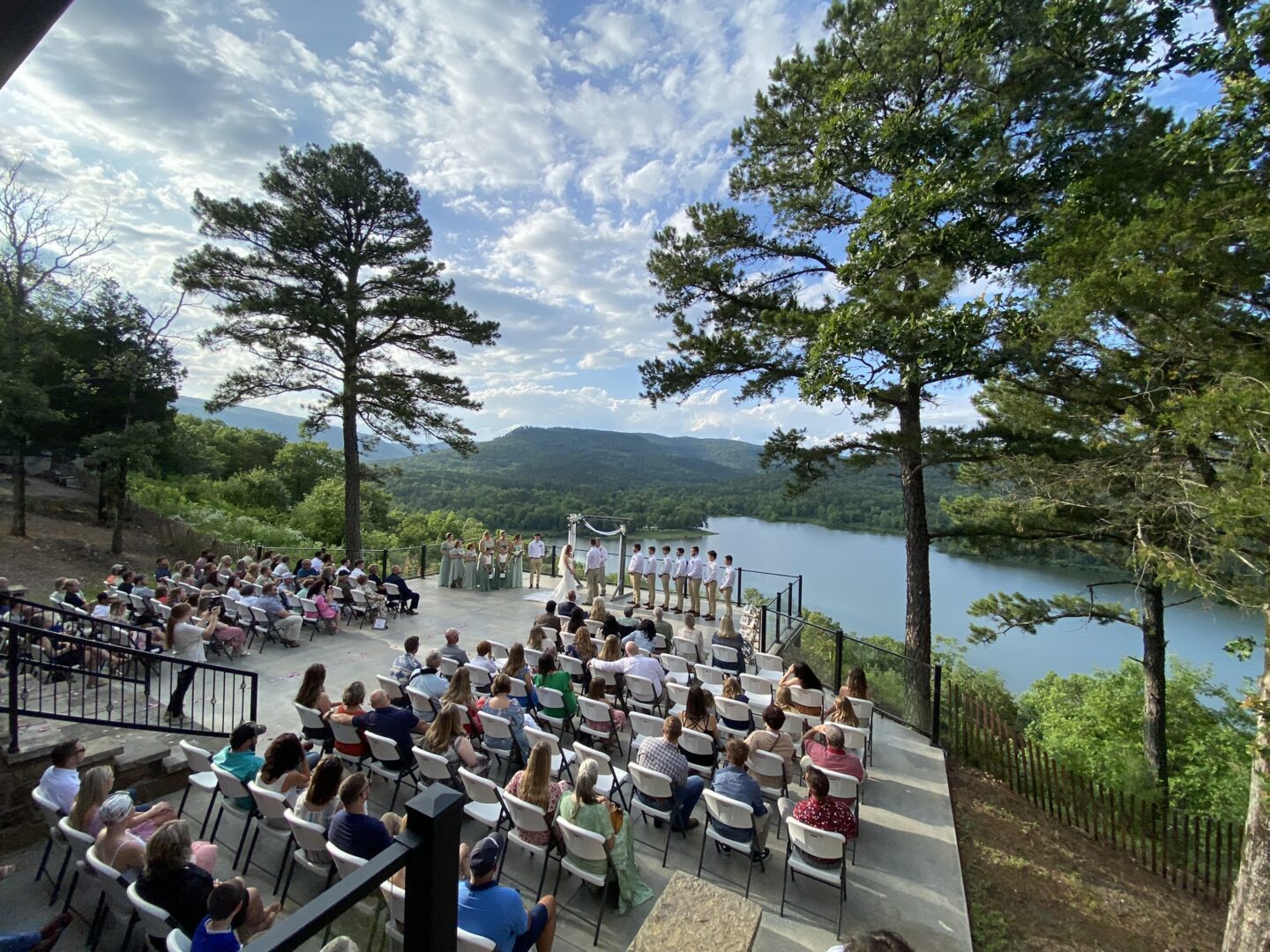 A crowd of people sitting on chairs near the water.