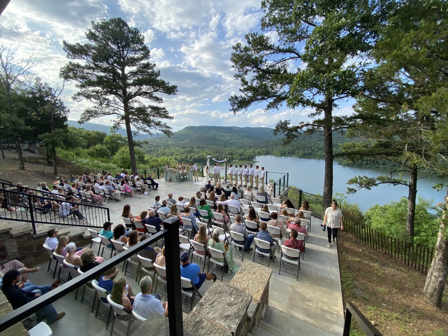 A crowd of people sitting on steps near water.